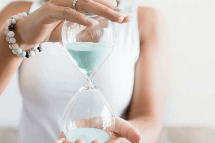 Lady holding an hourglass with blue sand