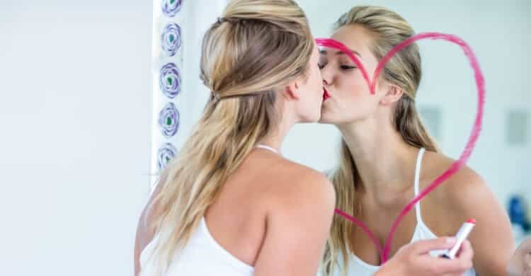 Ego-driven woman kissing her own reflection