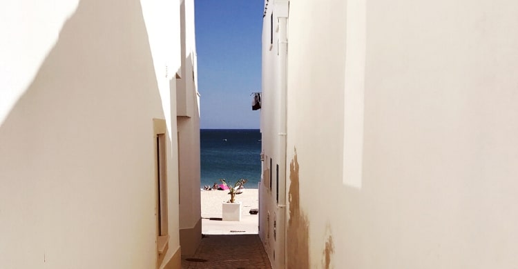 Narrow view between buildings onto beach