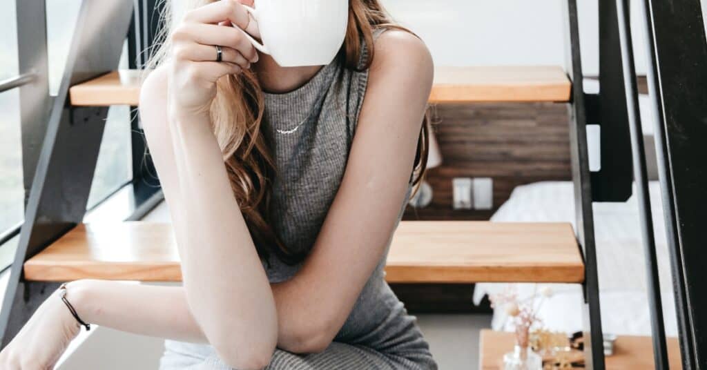 Woman drinking coffee, contemplating the true meaning of work-life balance
